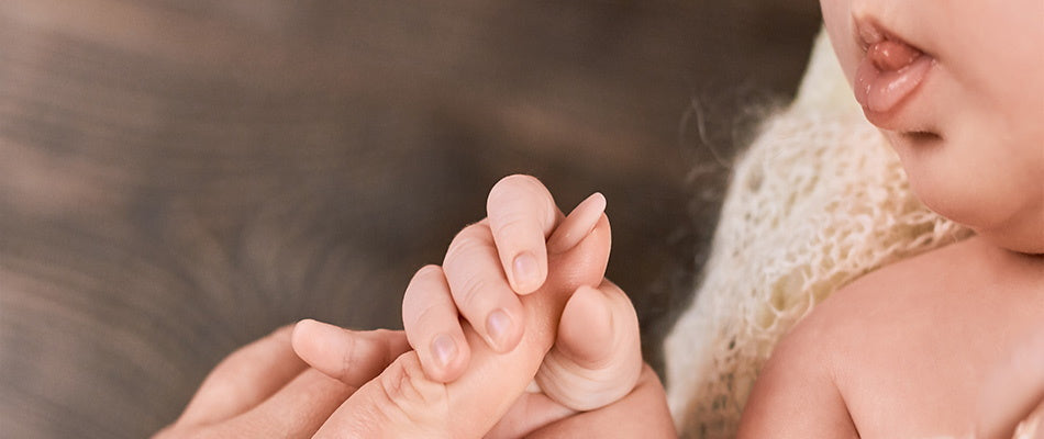 baby holding parent's hand