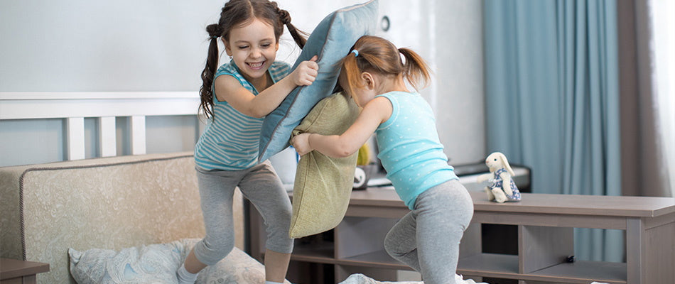 two girls pillow fighting